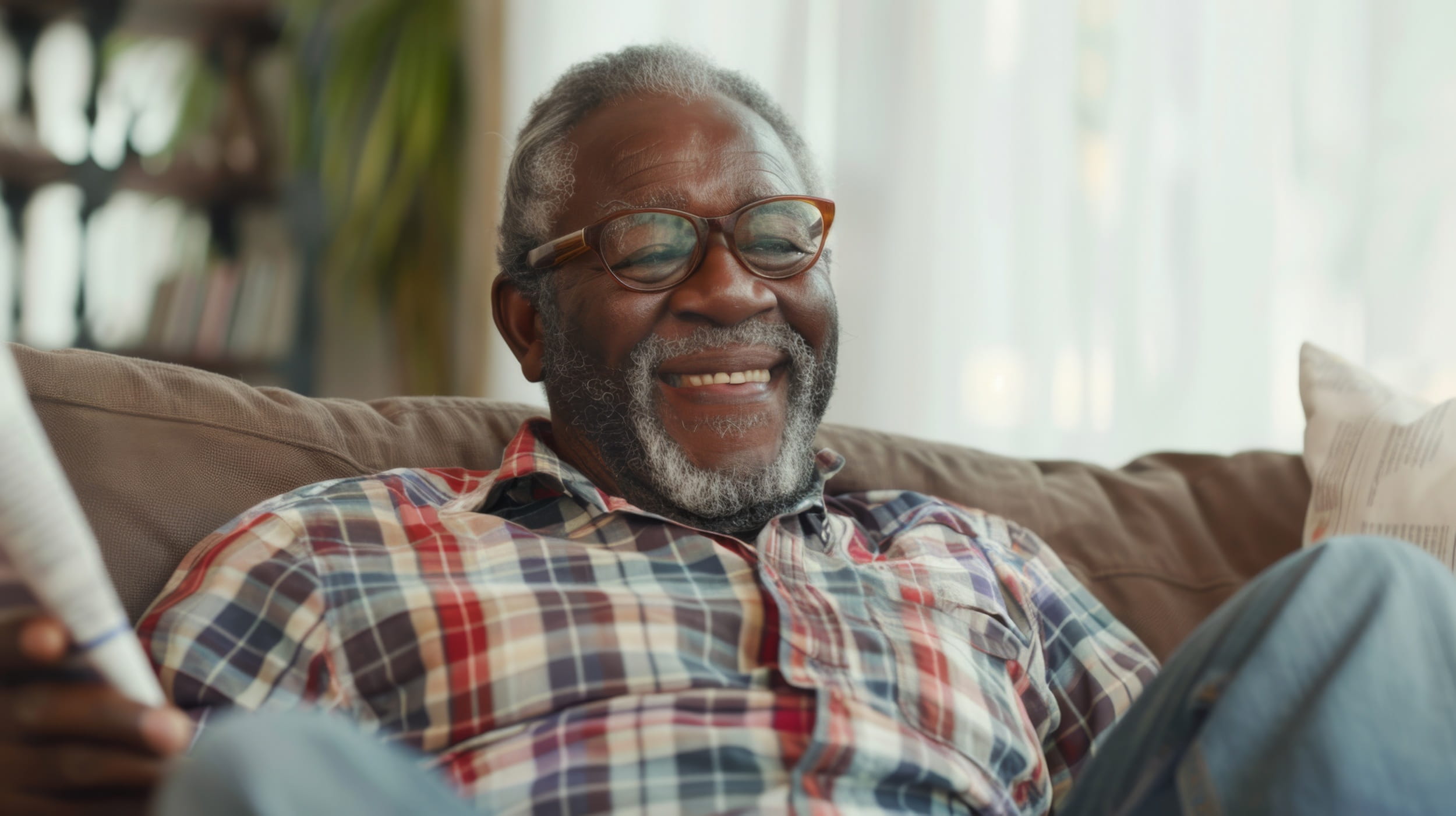A senior man smiling warmly and relaxing on a comfortable sofa, appearing refreshed and well-rested